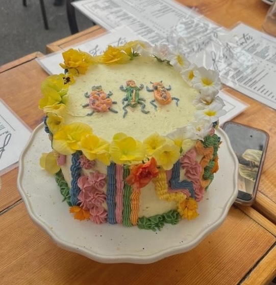 Rainbow striped cake with frosting bugs at restaurant